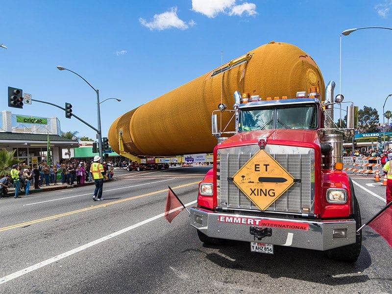 Orange external tank ET-94 on an Emmert transporter at a Los Angeles intersection