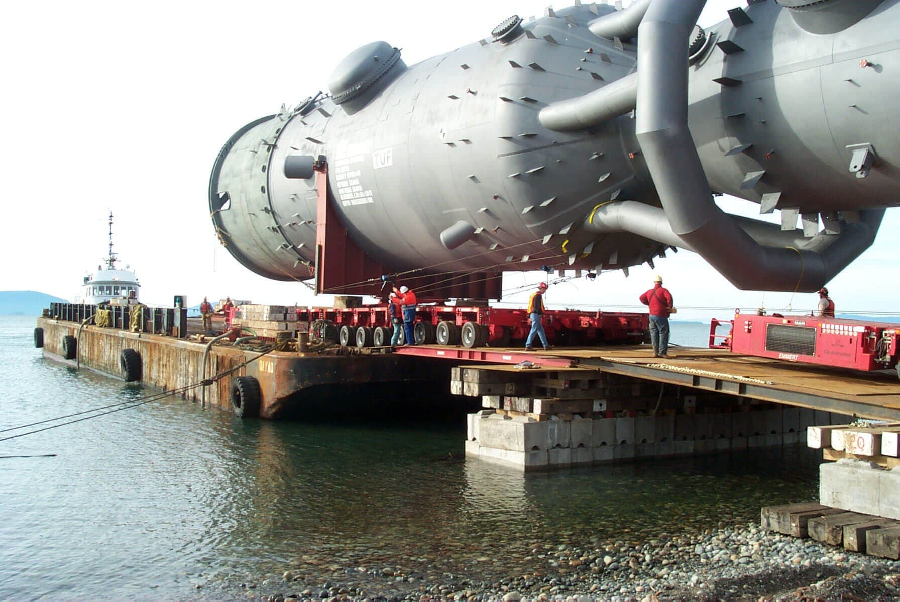 950-ton FCC converter on Emmert modular trailers rolling off a barge onto a cribbed beach landing