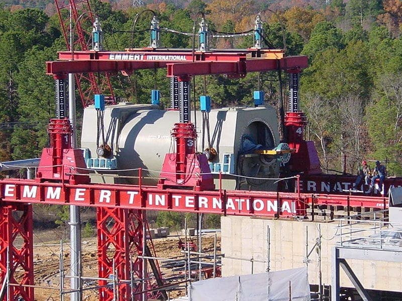 Red Emmert International lift tower system supporting a large component at an industrial site